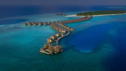 Overwater villas at Vakkaru Maldives extending across turquoise lagoon waters with panoramic ocean and island views