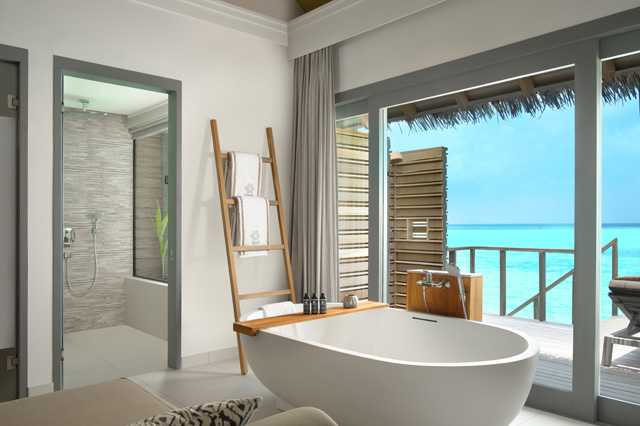 Vakkaru Maldives Over Water Villa Full indoor bathroom overlooking the lagoon