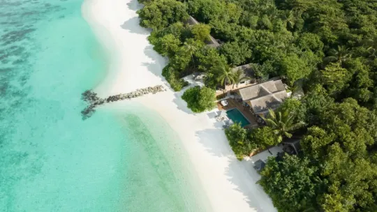 Aerial view of Vakkaru Maldives surrounded by turquoise lagoons and white sand beaches.