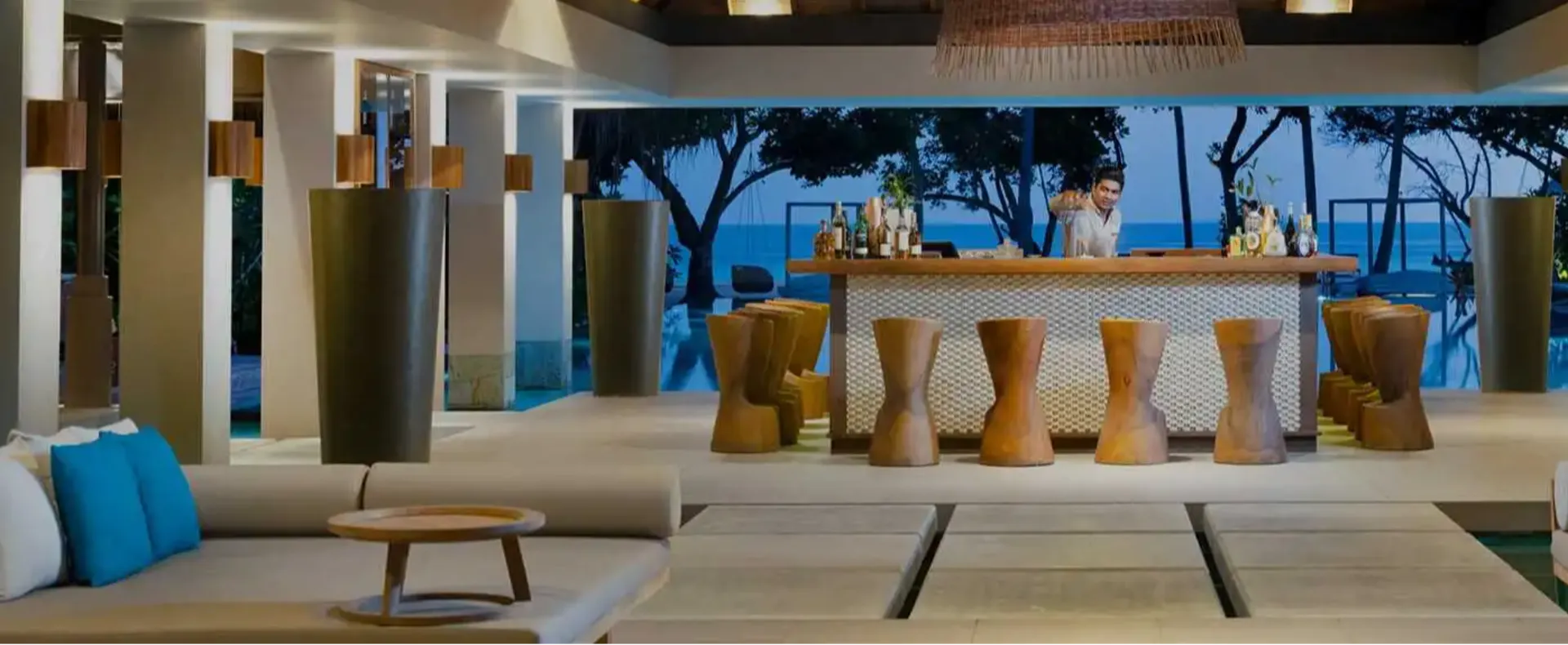 Cabana poolside lounge at Vakkaru Maldives with wooden stools and open-air bar