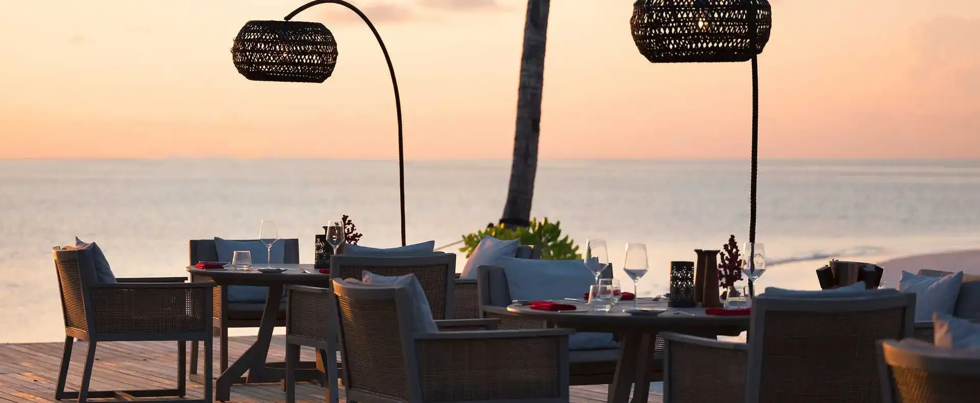 Outdoor beachfront dining area at Vakku restaurant in Vakkaru Maldives during sunset