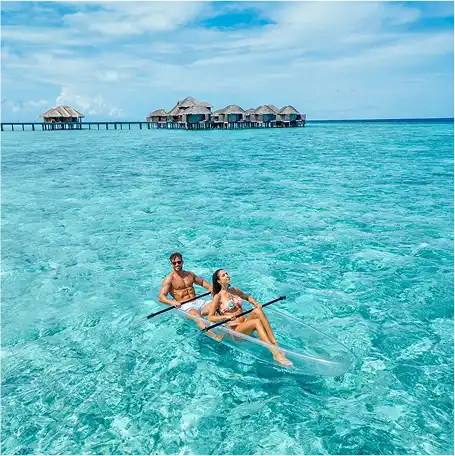 Couple enjoying a romantic honeymoon cruise at Vakkaru Maldives Residence surrounded by crystal-clear waters.