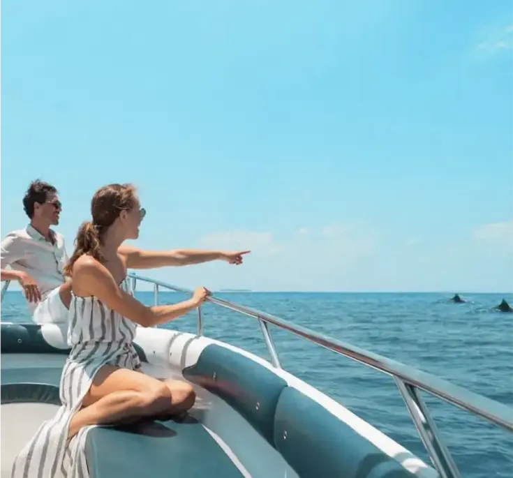 Couple enjoying a private boat excursion while spotting dolphins in the Maldives