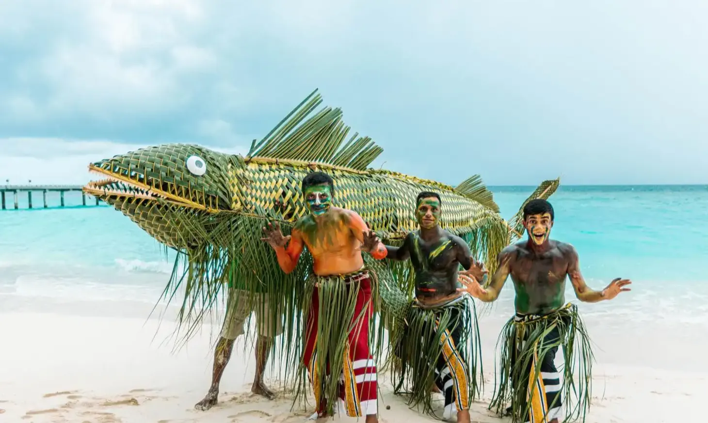 Signature woven fish sculpture on the beach at Vakkaru Maldives overlooking the ocean and island scenery.