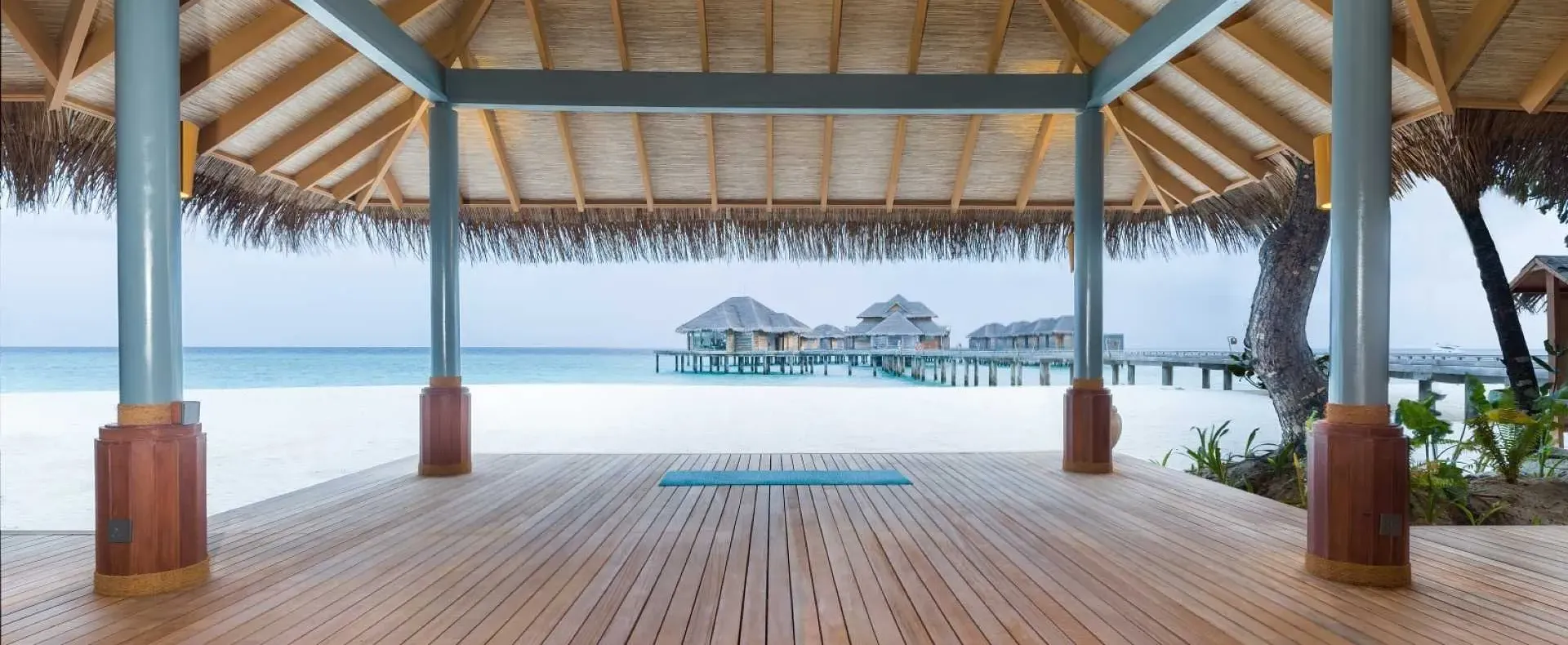 Beachfront yoga pavilion at Vakkaru Maldives overlooking the turquoise waters of the Indian Ocean.