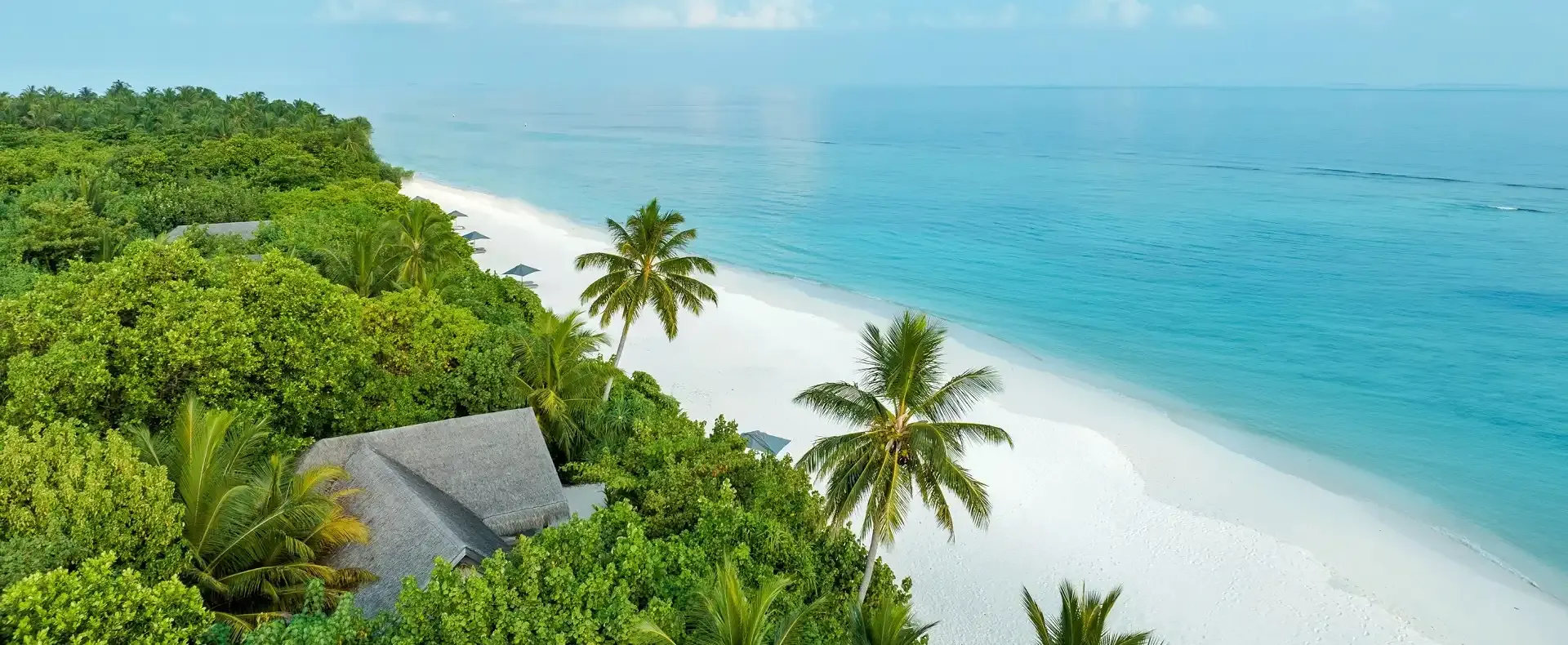 Aerial view of Vakkaru Maldives featuring tropical forest landscapes and pristine coastline.