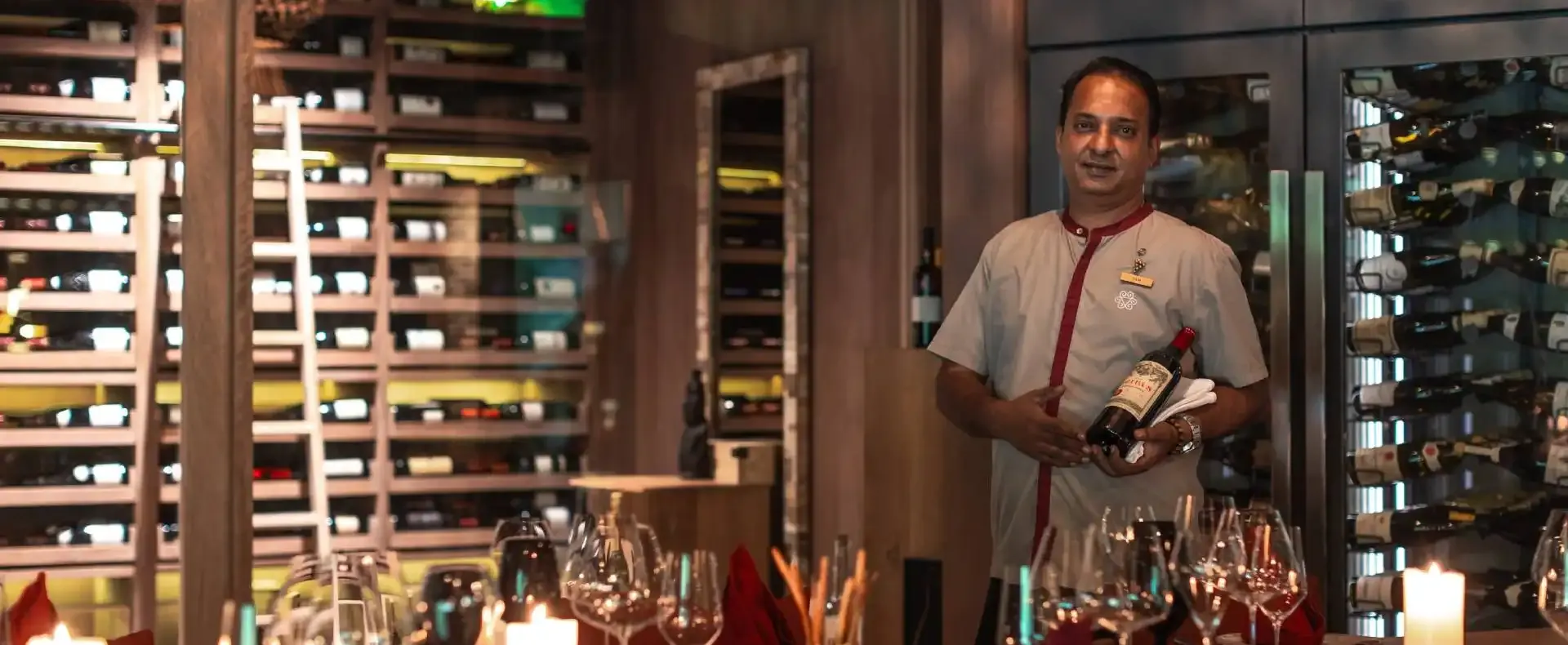 Guest exploring premium wine selections in the exclusive wine cellar at Vakkaru Maldives.