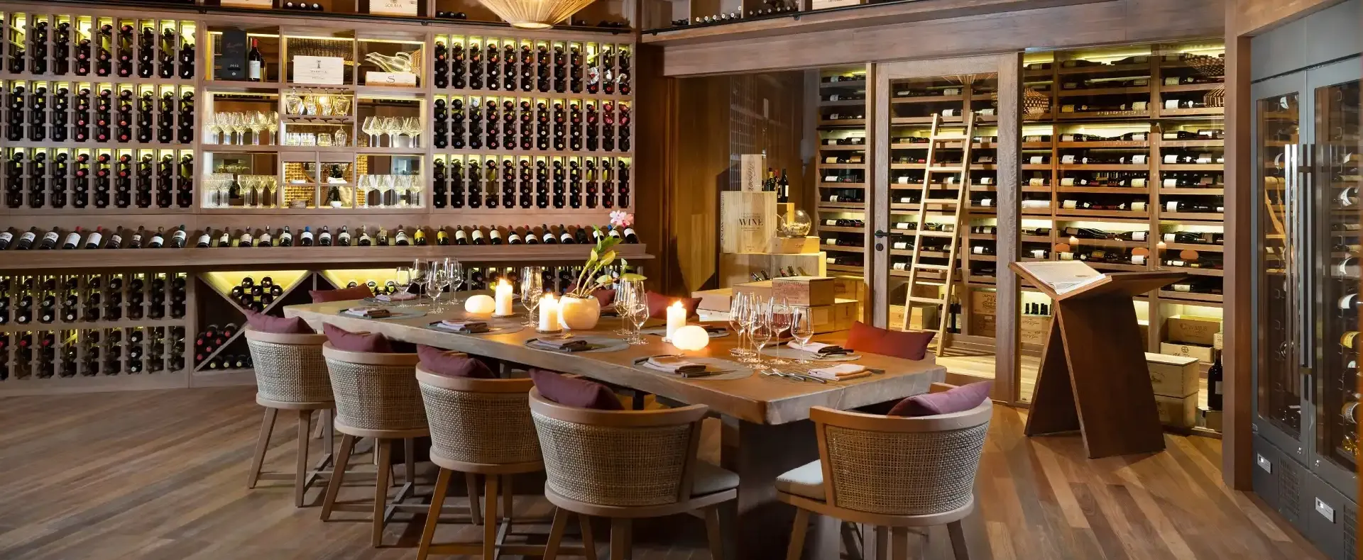 Elegant wine cellar dining experience at Vakkaru Residence surrounded by premium wine collections.