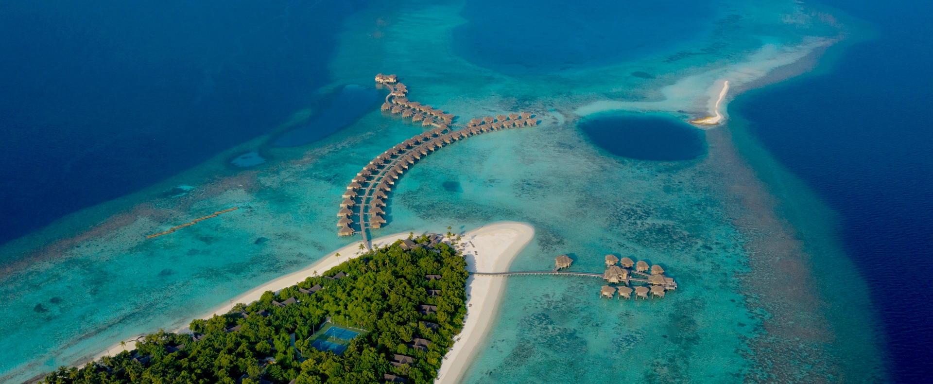 Aerial view of Vakkaru Maldives overwater villas extending into the lagoon