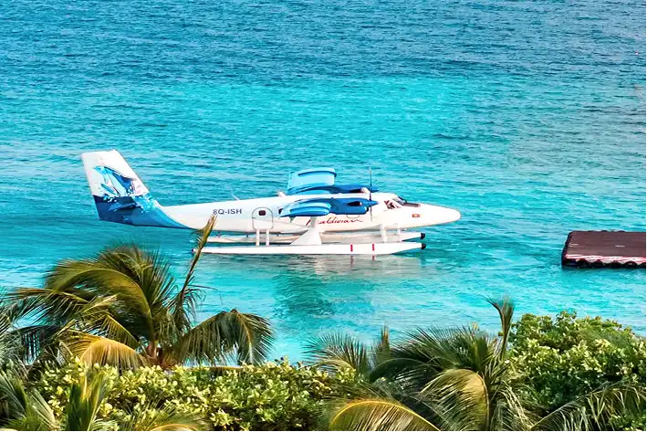 : Seaplane docked on floating platform at Vakkaru Maldives in turquoise water.