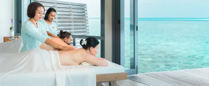 A couple enjoying a relaxing full-body massage side by side at Vakkaru Maldives