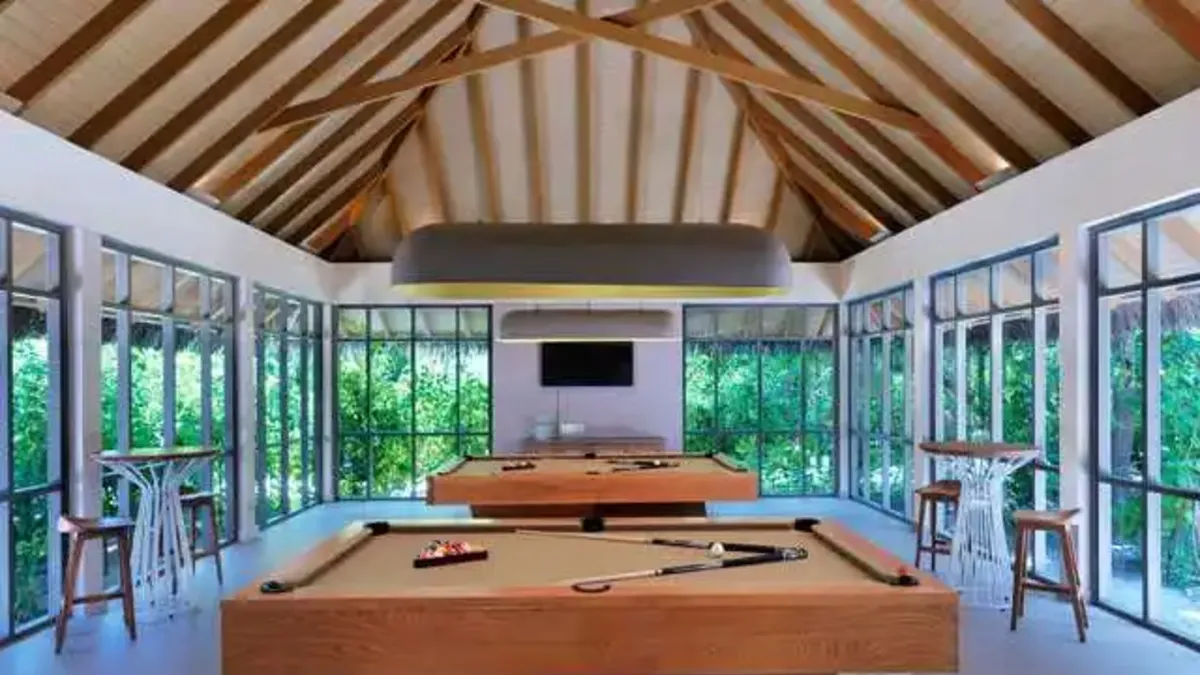 Recreation lounge at Vakkaru Maldives featuring pool tables, warm timber interiors and leisure facilities.