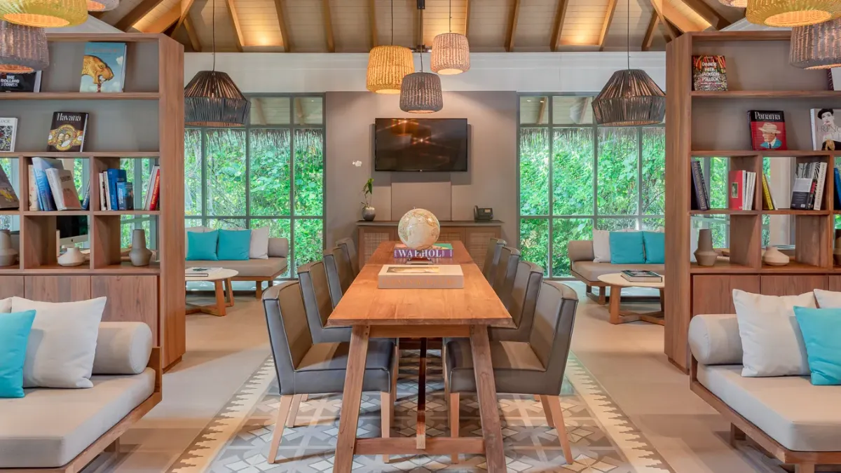 Stylish villa interior at Vakkaru Maldives with curated books, natural light and garden views.