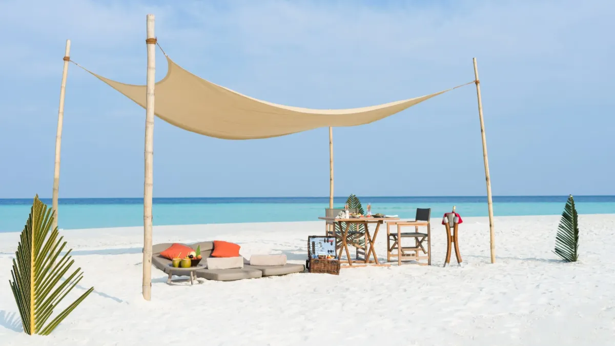 Private beach lounge at Vakkaru Maldives beneath a shaded canopy overlooking the tranquil turquoise ocean.