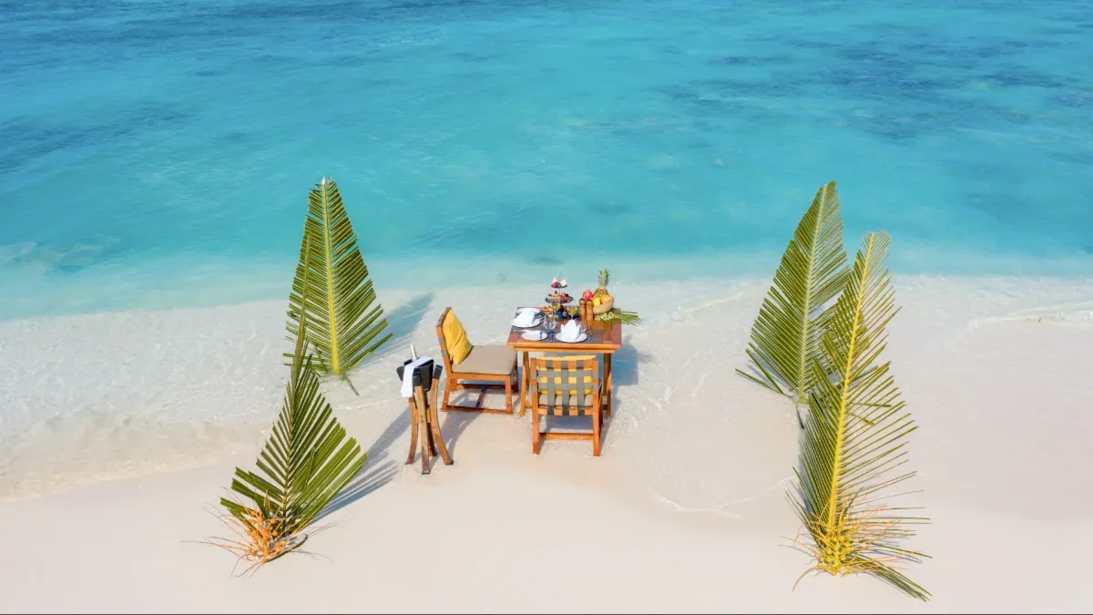 Romantic destination dining setup at Vakkaru Maldives with a private table overlooking the ocean.